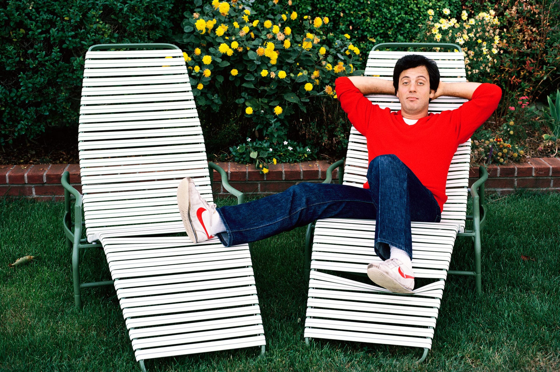 Man in red sweater relaxing on lawn chairs