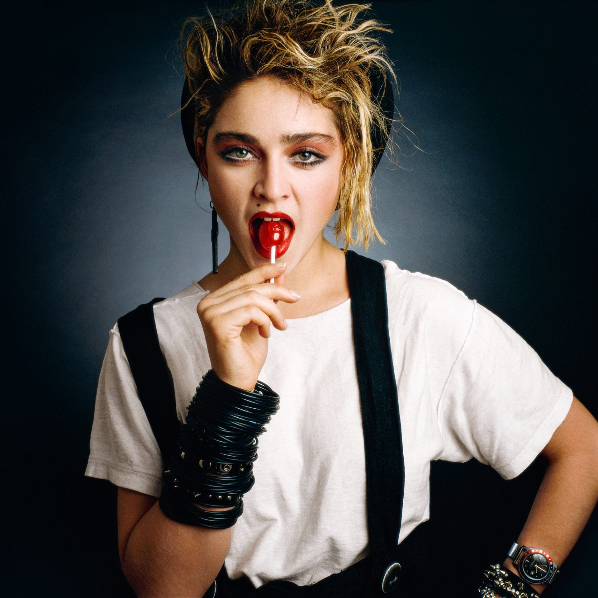 Woman with tousled hair licking red lollipop