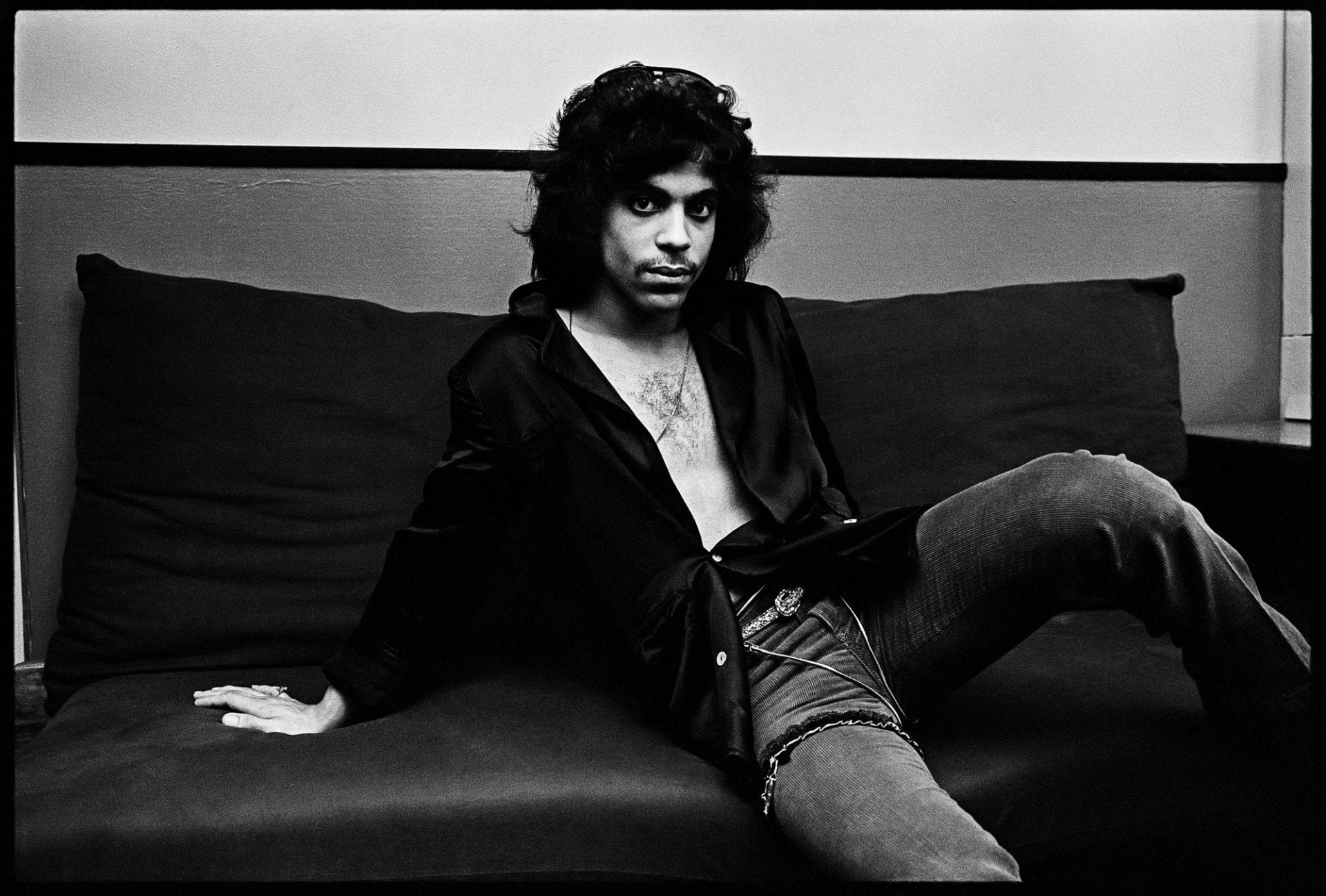 Black-and-white portrait of man lounging on sofa